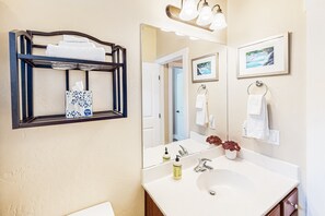 A bathroom with a large mirror, a sink, a towel rack, and a framed picture on the wall. - Stylish all-season home with dog-friendly yard, patio, central AC & washer/dryer (Flagstaff)