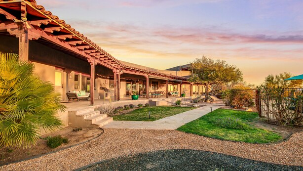 A traditional-style building with a covered patio area, outdoor seating, and a well-maintained garden. - Tucson ranch home with private pool, hot tub, gourmet kitchen, & patio (Marana)
