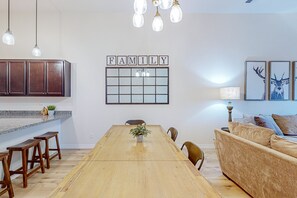 Eine moderne Küche mit Holzschränken, einem Holztisch und einem Schild mit der Aufschrift 'FAMILY'.