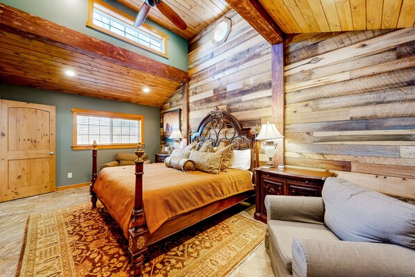 A bedroom with a wooden bed, a wooden headboard, a nightstand, a lamp, a window, and a door. - Downtown guest house with yard, grill, streaming, fireplace, & washer/dryer (Flagstaff)