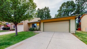 Una casa residenziale con garage, vialetto e prato.
