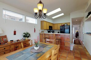 A spacious kitchen with wooden cabinets, a central island, and a dining area with a table and chairs. - Bright home in Sun City with large patio & on-site golf & swimming! (Oro Valley)