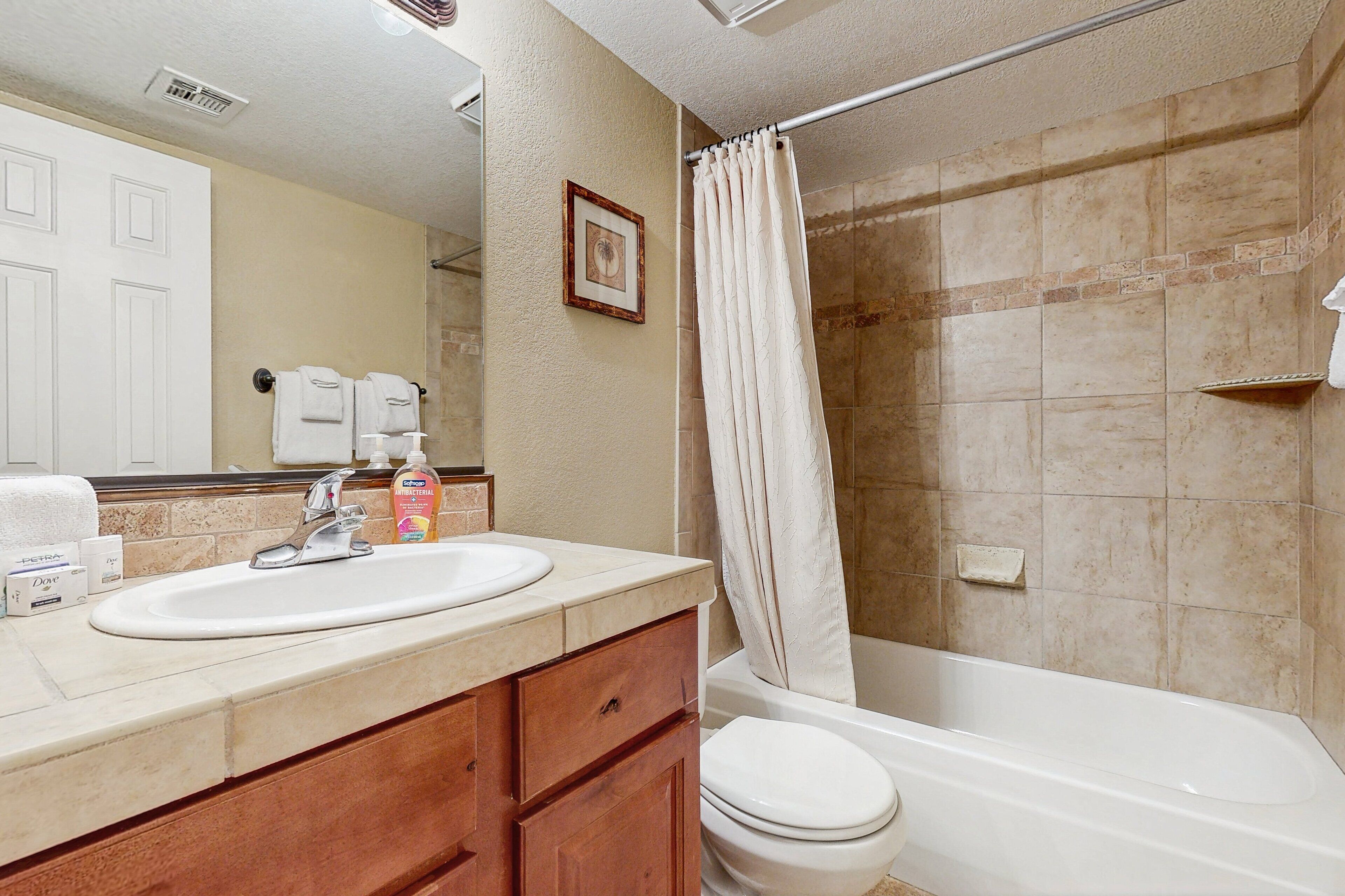 A bathroom with a sink, toilet, and shower.
