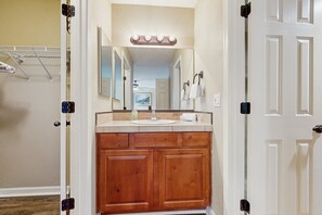 Une salle de bain avec des meubles en bois, un lavabo et un miroir.