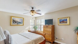 A bedroom with a bed, a dresser, a ceiling fan, and two framed pictures on the walls. - Comfortable, Single-Level Condo with Free WiFi, Washer/Dryer, & Shared Pool (Tucson)