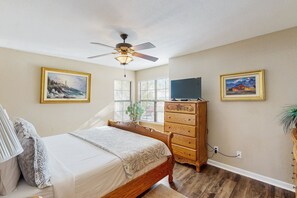 A bedroom with a bed, a dresser, a ceiling fan, and two framed pictures on the walls. - Comfortable, Single-Level Condo with Free WiFi, Washer/Dryer, & Shared Pool (Tucson)