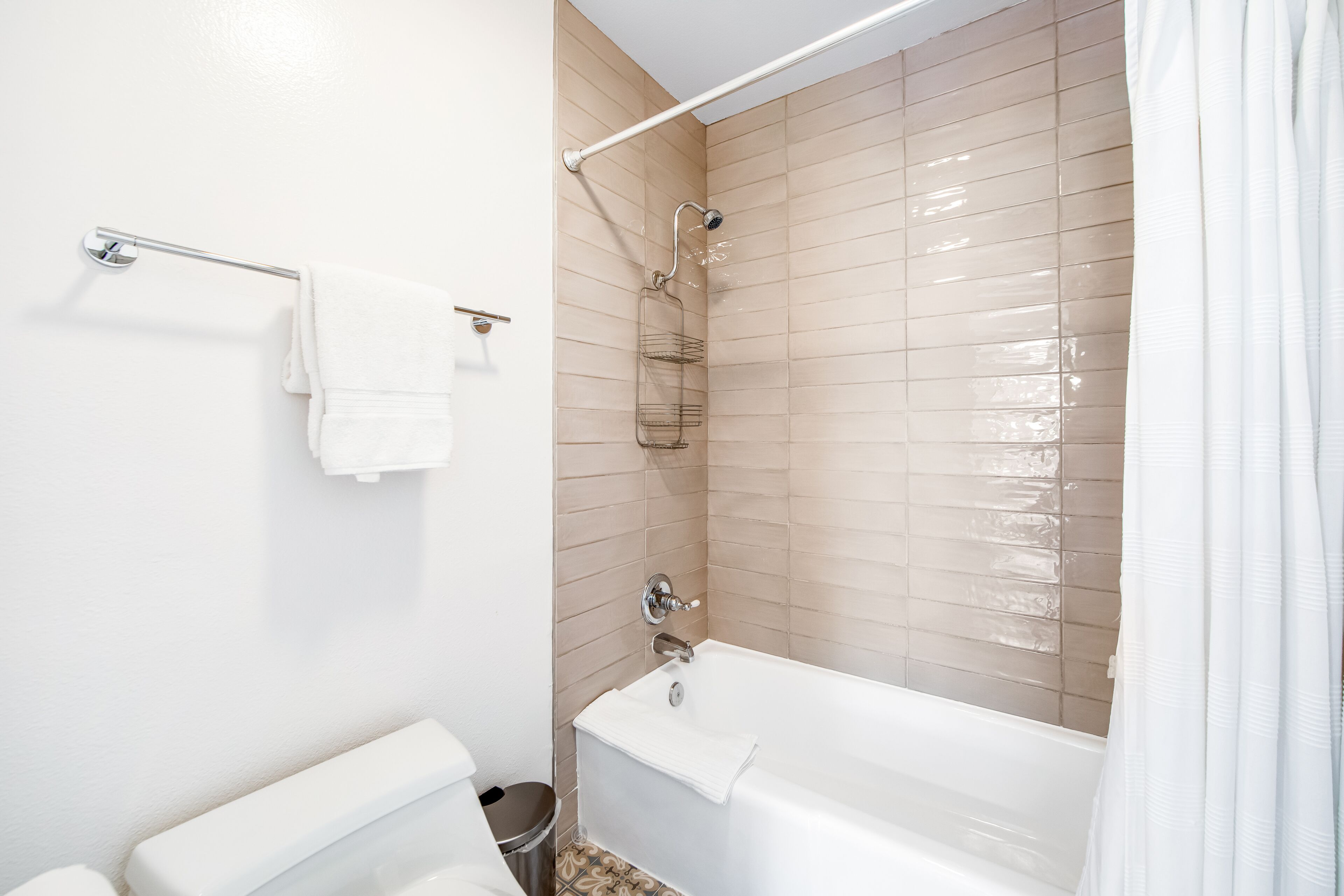 Een badkamer met een bad, een toilet en een douche.