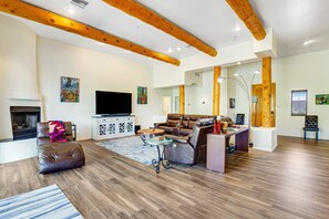 Ein geräumiges Wohnzimmer mit Kamin, Ledersofa und Fernseher.
