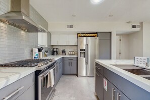A modern kitchen with stainless steel appliances, a built-in oven, and a water dispenser. - Relax, dine, and explore with ease soak up the sunshine. Home is Dog Friendly. (Palm Springs)