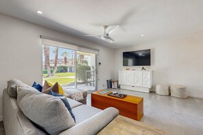 A modern living room with a sofa, coffee table, and a TV mounted on the wall. - Relax, dine, and explore with ease soak up the sunshine. Home is Dog Friendly. (Palm Springs)
