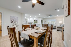 Ein Essbereich mit Holztisch, Stühlen und Deckenventilator.