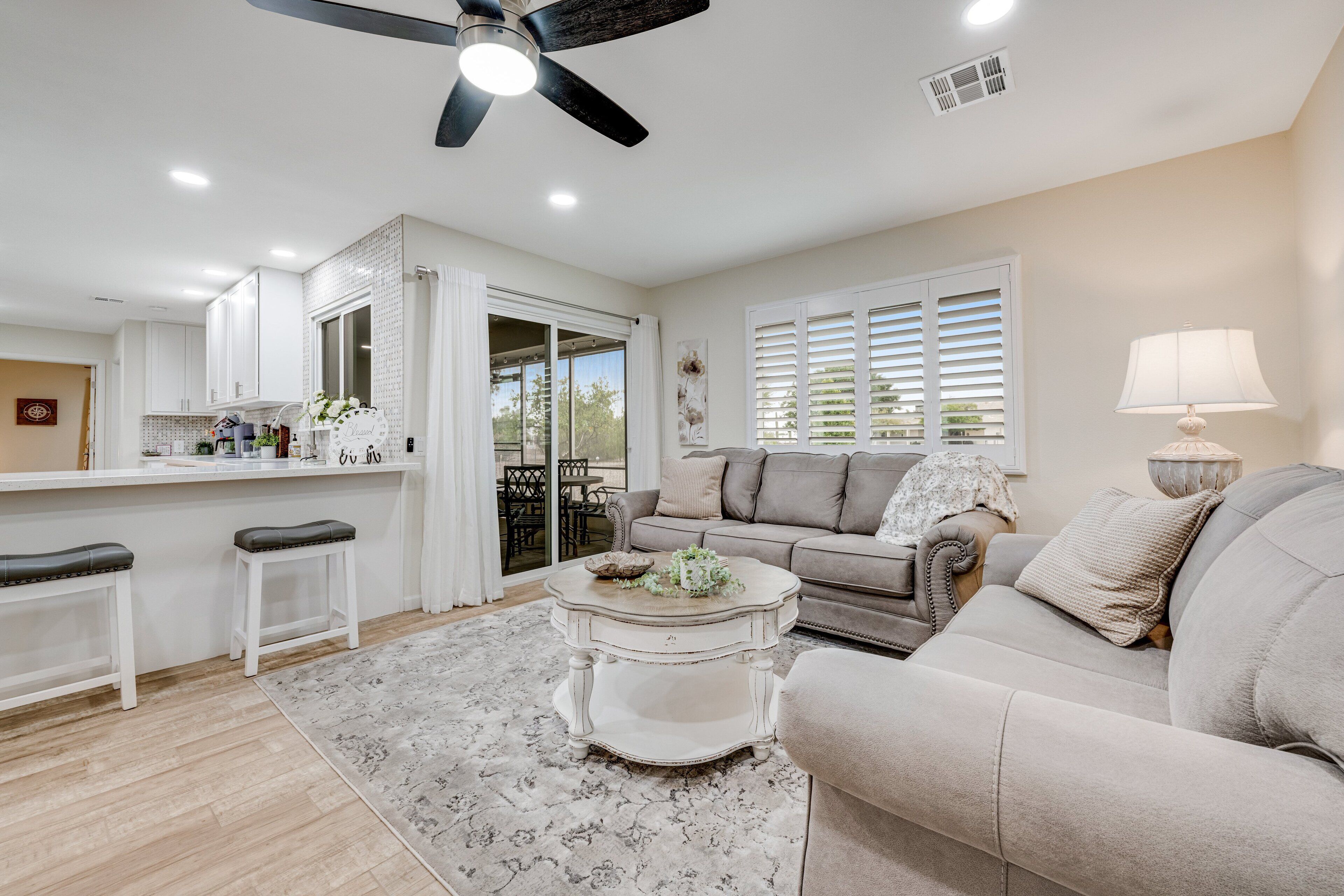 A spacious living area with a sofa, coffee table, and a dining area with a counter.