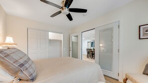 A bedroom with a bed, a ceiling fan, a chair, and a door leading to another room. - Ground-Floor Home w/Valley Views, Central A/C, Fast WiFi, & Private Washer/Dryer (Sun City)