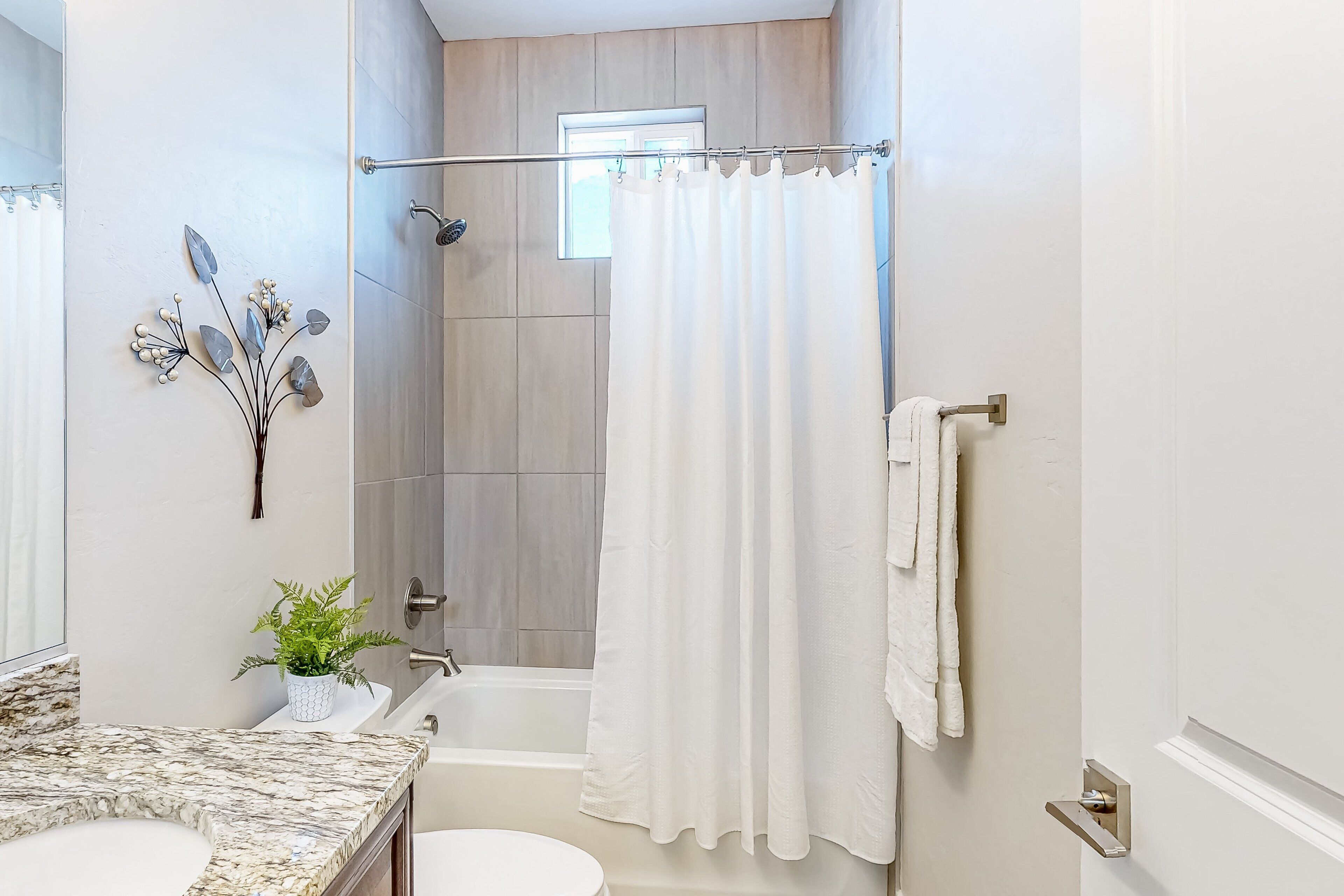 A bathroom with a bathtub, toilet, and sink.