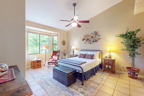 A bedroom with a bed, bedside tables, a chair, a desk, a floor lamp, a ceiling fan, and a potted plant. - Sunny townhome with a lovely patio & W/D - pool, game room, and gym access (Oro Valley)