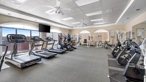 Un gimnasio con cintas de correr, elípticas y equipamiento de pesas.