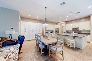 A modern kitchen with white cabinets, a central island, and a chandelier. - Beautiful desert home near trailheads with yard, grill, and mtn views - dogs ok (Phoenix)