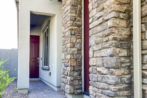 A stone exterior with a red door and a small entryway. - Beautiful desert home near trailheads with yard, grill, and mtn views - dogs ok (Phoenix)