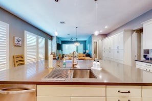 A modern kitchen with a central island, stainless steel appliances, and a view into the dining area. - Beautiful desert home near trailheads with yard, grill, and mtn views - dogs ok (Phoenix)