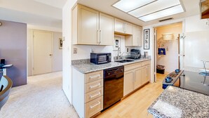 A modern kitchen with a dishwasher, microwave, and granite countertops. - Gorgeous condo with hot tub, pool, tennis court, & grilling area - lake access (Phoenix)