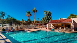 A swimming pool with clear blue water, surrounded by lounge chairs and palm trees. - Gorgeous condo with hot tub, pool, tennis court, & grilling area - lake access (Phoenix)