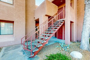 A staircase with red railings leading to a building entrance. - Mountain view stay with fireplace, resort-style amenities, central AC, & W/D (Tucson)