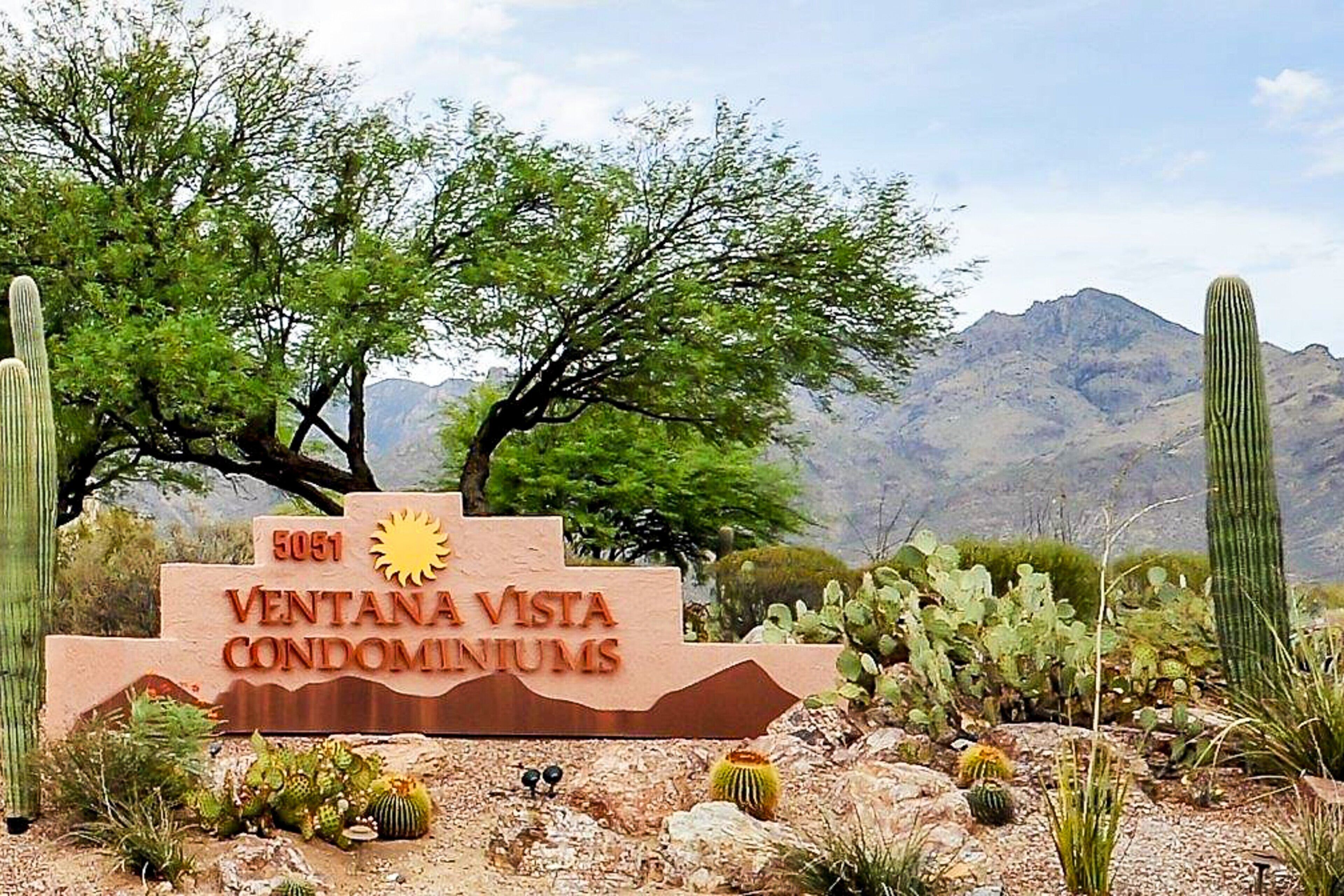 A sign for Ventana Vista Condominiums with a desert landscape in the background.