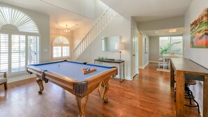 A spacious room with a pool table, wooden flooring, and a staircase leading to another level. - Delightful golf escape with pool, lawn games, pool table, fast WiFi & central AC (Phoenix)