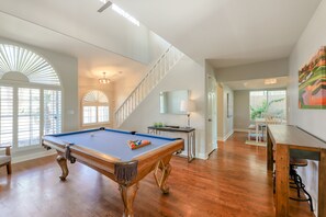 A spacious room with a pool table, wooden flooring, and a staircase leading to another level. - Delightful golf escape with pool, lawn games, pool table, fast WiFi & central AC (Phoenix)