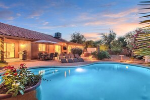 A swimming pool with lounge chairs and a patio area with outdoor seating. - Contemporary home with a private pool, hot tub & fast WiFi (Scottsdale)