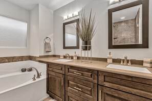 A bathroom with a bathtub, two sinks, a mirror, and a potted plant. - Contemporary home with a private pool, hot tub & fast WiFi (Scottsdale)