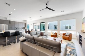 A modern living space with a sofa, coffee table, and a ceiling fan. - 3-suite home on 2.5 acres, complete with a private pool & large furnished patio (Scottsdale)