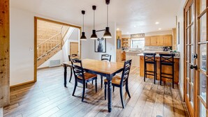 A spacious kitchen with wooden cabinets, a central island, and pendant lighting.