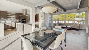 Eine moderne Küche mit Essbereich, großen Fenstern und einem Deckenventilator.