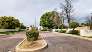 A residential street with a well-maintained lawn, a sign for Quail Point, and a clear sky. - Sun Valley condo with a patio, washer/dryer, & AC - pool, hot tub, grill access (Scottsdale)