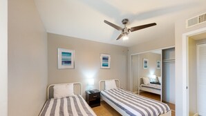 A bedroom with two single beds, a ceiling fan, and a nightstand with a lamp. - Sun Valley condo with a patio, washer/dryer, & AC - pool, hot tub, grill access (Scottsdale)