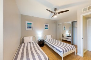 A bedroom with two single beds, a ceiling fan, and a nightstand with a lamp. - Sun Valley condo with a patio, washer/dryer, & AC - pool, hot tub, grill access (Scottsdale)