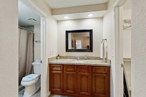 A bathroom with a wooden vanity, a sink, and a mirror. - Stylish & Spacious Condo with Pool, Spa & Gym | Minutes to Golf (Scottsdale)