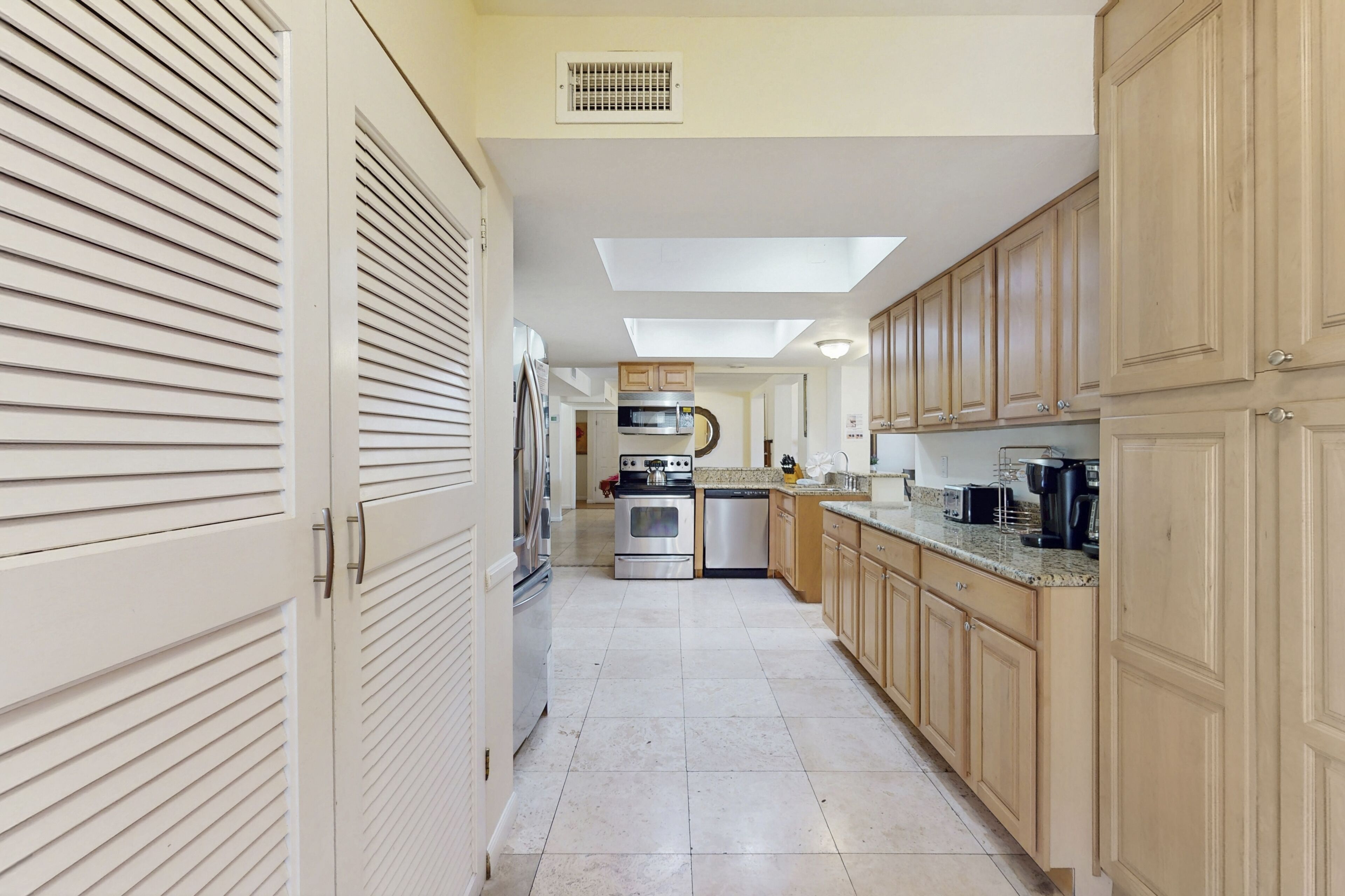 A kitchen with a central island, built-in appliances, and a view to the living area.