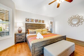 Un dormitorio con cama de madera, una mesita de noche, una lámpara y una ventana con persianas.