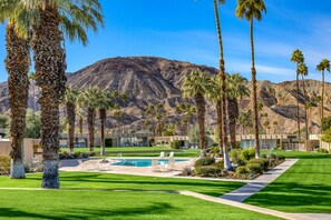 Ein Resort mit Swimmingpool, Palmen und einem Berg im Hintergrund.