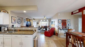 A spacious kitchen with granite countertops, white cabinets, and a central island. - Dog-friendly, ground-floor condo with patio, desert views, pool, hot tub, & W/D (Oro Valley)