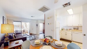 Un salon moderne comprenant un coin repas, une cuisine et donnant sur l’extérieur.