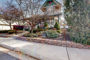 Ein zweistöckiges Haus mit Veranda, Briefkasten und gepflegtem Garten.