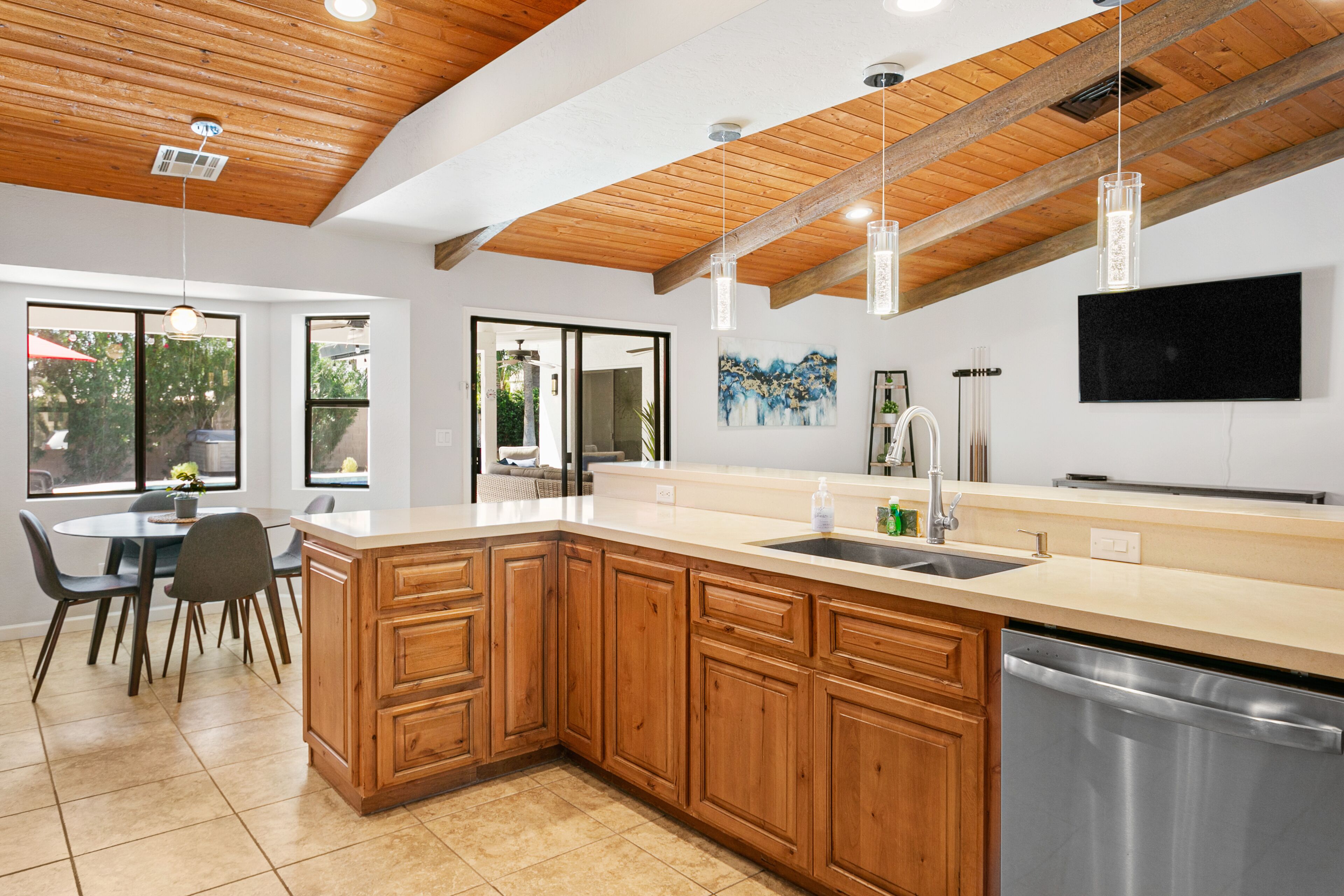 A modern kitchen with wooden cabinets, a large island, and a built-in dishwasher.