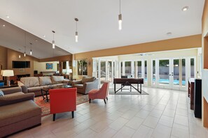A spacious living room with a large sofa set, a red armchair, and a pool table. - Relax at this remodeled home & casita w/ private pool & spa - 2 dogs OK (Palm Springs)
