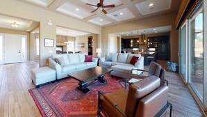 A spacious living area with a large sofa, a coffee table, and a fireplace.
