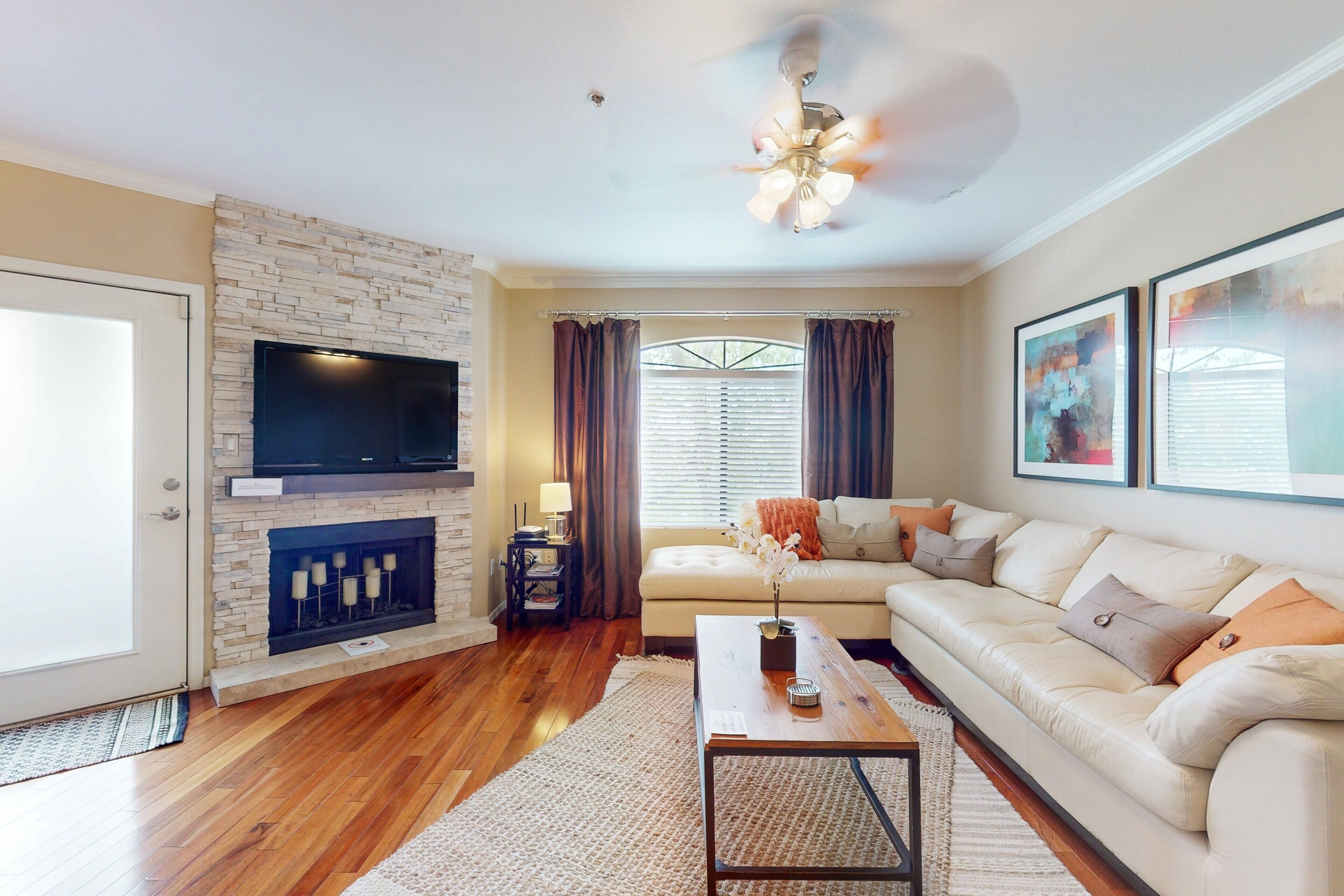 A living room with a fireplace, a sofa, a coffee table, and a television.
