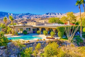 A Mediterranean-style villa with a swimming pool, outdoor seating, and a view of mountains. - Mountain-view retreat with amazing views of Palm Desert city lights & pool (Palm Desert)