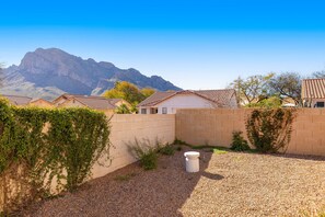 A residential area with houses, a gravel driveway, and a mountain in the background. - Spacious home with mountain views, grill, central air-conditioning, & free WiFi (Oro Valley)